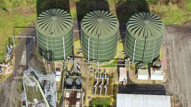 Aerial view of industrial tanks, pipes, and structures creates a textured landscape contrasting with the surrounding greenery, Severn Trent Water, Coleshill, United Kingdom.