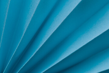 Obraz premium Light blue folded paper creates a pattern showing lines and curves in a simple design during daylight hours
