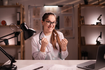 Portrait of female doctor or medical student intern with stethoscope celebrating win victory...