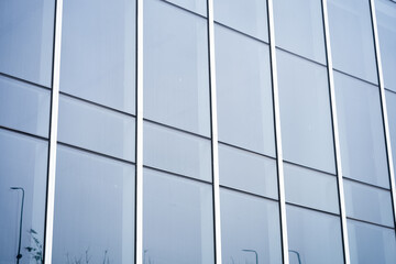 Modern glass curtain wall architecture detail close-up with geometric lines and reflective surfaces