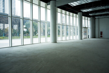Fototapeta premium Spacious modern office building lobby with floor-to-ceiling windows and concrete interior