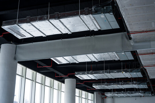 Modern interior space with exposed ceiling structure featuring steel beams and ductwork