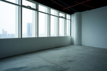 Naklejka premium Empty modern office space with floor-to-ceiling windows overlooking city skyline