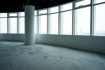 Naklejka premium Empty office interior with floor-to-ceiling windows, white column, and concrete floor