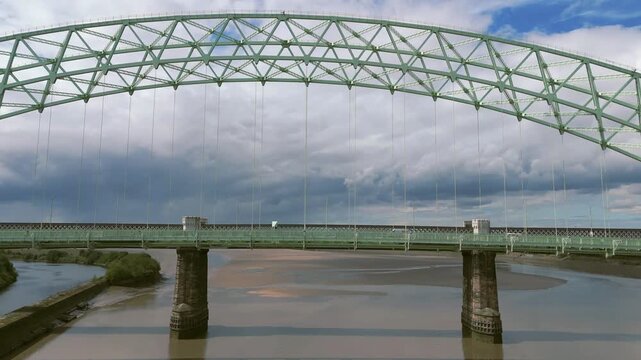 Liverpool, Merseyside, UK, September 09, 2025; aerial 4K video footage of the Silver Jubilee Bridge and Britannia Railway Viaduct over the River Mersey and Manchester Ship Canal, Runcorn, Merseyside