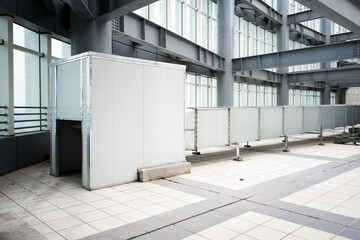 Naklejka premium White temporary partition and barrier inside industrial factory with steel framework and tiled floor