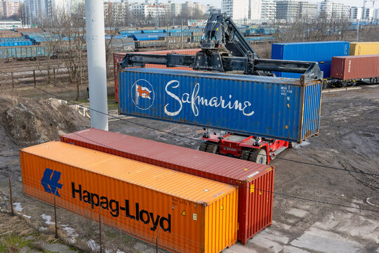 WARSAW, MASOVIAN, POLAND - FEBRUARY 27 2026: A reach stacker lifting a blue Safmarine container.