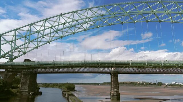 Liverpool, Merseyside, UK, September 09, 2025; aerial 4K video footage of the Silver Jubilee Bridge and Britannia Railway Viaduct over the River Mersey and Manchester Ship Canal, Runcorn, Merseyside