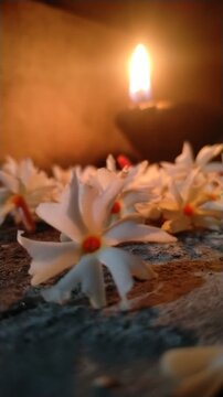 Traditional Oil Lamp with Night Jasmine Flowers Burning in Dark Spiritual Background	