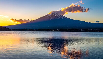 Snow capped Mount Fuji rising above calm lake at sunrise with soft clouds reflecting on tranquil water landscape