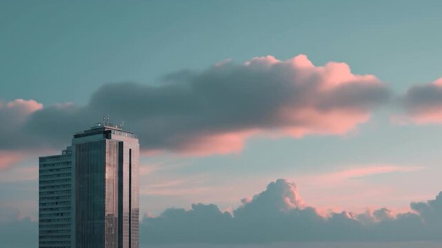 Dramatic sunset sky over highrise city buildings with clouds and architecture.