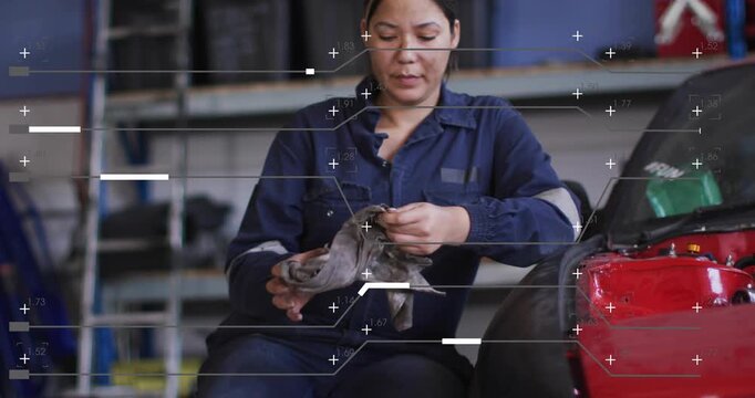 Camera close-up on hands, tech sitting in garage, folding rag, cleaning grime while overlays moving