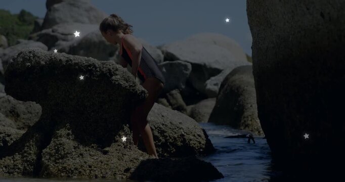 Child stepping on barnacled rock, leaning while exploring pool, stars drifting over child education