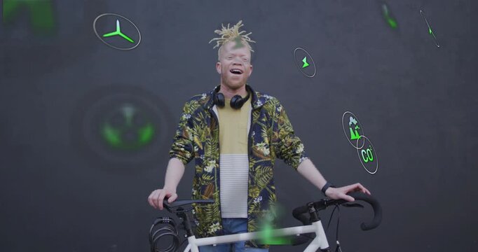 Man holding bike in studio, reacting to appearing green energy icons by smiling and laughing