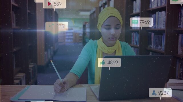 Student glancing at laptop and writing paper at library, activating social bubbles tracking metrics