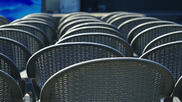 Rows of empty chairs stand in front of the stage before the start of a performance or concert.