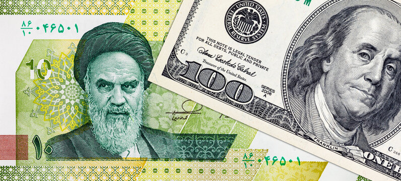 US Dollar and Iranian Rial Banknotes with portraits of Benjamin Franklin and Ruhollah Khomeini. War between the United States and Iran.