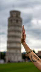 Fototapeta premium University graduate under the Leaning Tower in Pisa with laurel crown striking iconic pose