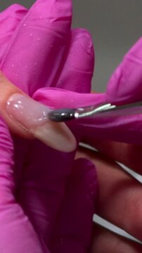 Closeup Acrylic Nail Sculpting With Brush And Pink Gloves Applying Builder Material For Extension. Media