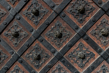 Obraz premium Detailed Texture of Antique Iron Door with Forged Lattice and Rosettes
