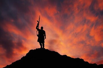 Fototapeta premium Silhouette of a Victorious Armed Fighter on a Hill at Sunset