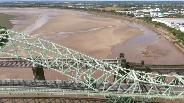 Liverpool, Merseyside, UK, September 09, 2025; aerial 4K video footage of the Silver Jubilee Bridge and Britannia Railway Viaduct over the River Mersey and Manchester Ship Canal, Runcorn, Merseyside