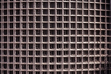Steel wire mesh forming a repetitive geometric pattern and industrial background texture © Довидович Михаил