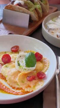 Homemade ravioli pasta italian cuisine hands cutting a piece. Dumpling filled cheese tortellini. High quality FullHD footage