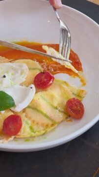 Homemade ravioli pasta italian cuisine hands cutting a piece. Dumpling filled cheese tortellini. High quality FullHD footage