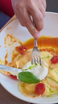 Homemade ravioli pasta italian cuisine hands cutting a piece. Dumpling filled cheese tortellini. High quality FullHD footage