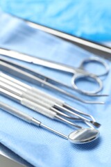 Naklejka na ściany i meble Different dental tools and medical napkin on table, closeup
