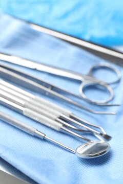 Different dental tools and medical napkin on table, closeup