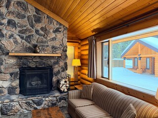 Naklejka premium Cozy room with fireplace, couch and wooden table