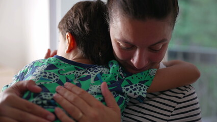 Mother holding young boy in a close embrace, comforting hug, deep bond, mother-son love, emotional...