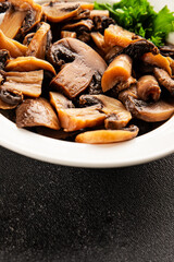 Fototapeta premium Champignon mushrooms ready to eat tasty snack fresh gourmet food background on the table rustic food top view copy space keto and paleo diet vegetarian and vegan food marketing concept photo