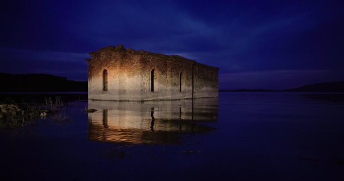 Abandoned sunken church in dam Zhrebchevo Reservoir, Sliven Region, Bulgaria scenic landscape by night