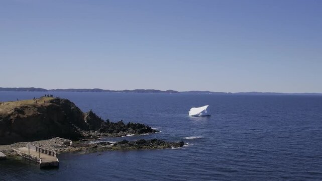 Tourist viewing an iceberg near shore, Newfoundland and Labrador, Canada. 
