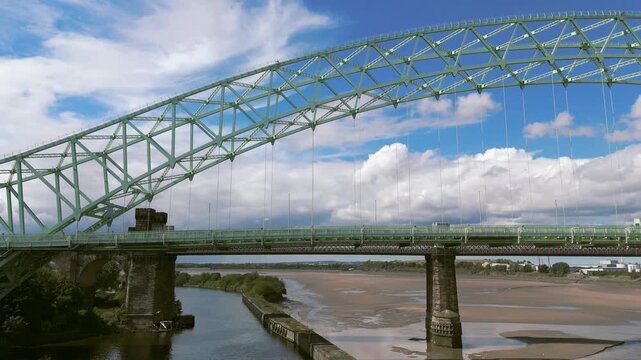 Liverpool, Merseyside, UK, September 09, 2025; aerial 4K video footage of the Silver Jubilee Bridge and Britannia Railway Viaduct over the River Mersey and Manchester Ship Canal, Runcorn, Merseyside