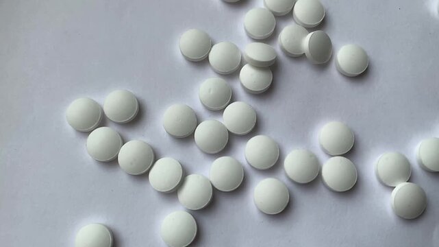 Many pills in the hand. A man takes a handful of white pills, suicide. Treatment for an illness.