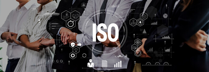 A diverse group of business professionals stands united with arms crossed, emphasizing teamwork and commitment to ISO standards in a modern corporate environment. Trope © InfiniteFlow