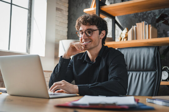Office, laptop and man with glasses, happy and risk assessment for investment proposal and research. Business, financial analyst and person with tech for asset management, smile and budget review