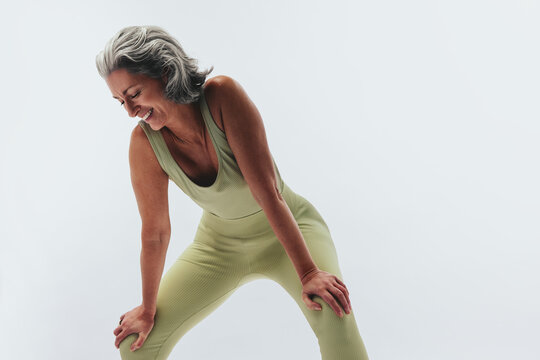 Woman laughing and bending forward in studio stretch