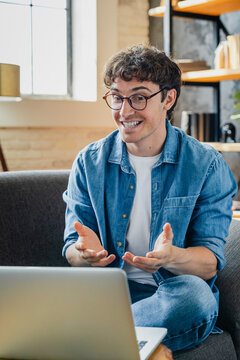 Laptop, video call and man in home with remote work for online meeting webinar communication. Computer, freelancer and male on virtual workshop for creative project in apartment. Vertical shot