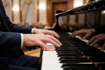 Fototapeta premium Man in a suit playing a grand piano during a classical music concert
