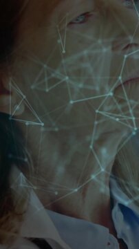 Vertical video: Senior doctor touching chin causing nodes forming into teal shield securing data