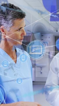 Vertical video: Doctor gesturing pen initiating HUD sync, nurse leaning and tapping at nurses' desk