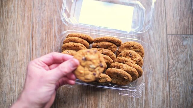 Butterscotch pretzel cookies stack with dark chocolate chip sweet food hand holding one cookie macro closeup