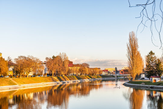 Sunset Bosut River Reflection Along City Promenade With Trees, Bridge and Tranquil Evening Light, Vinkovci, Croatia