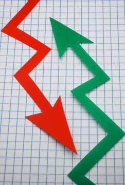 Arrows cut out of colored paper imitating a graphic chart of increase or decrease.
