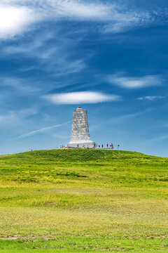 Wright Brothers monument standing on open landscape beneath summer clouds
